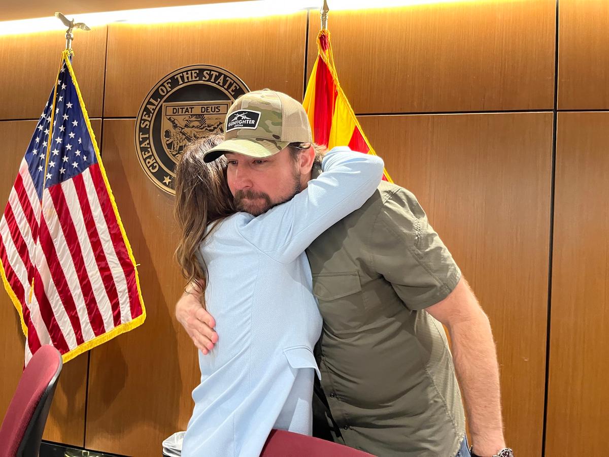 U.S. Rep. Eli Crane (R-Ariz.) receives a hug of appreciation from Sara Carter, director of the Office of National Drug Control Policy, for his work supporting stronger border security policy during a panel discussion in Phoenix, on May 28, 2026. (Allan Stein/The Epoch Times)