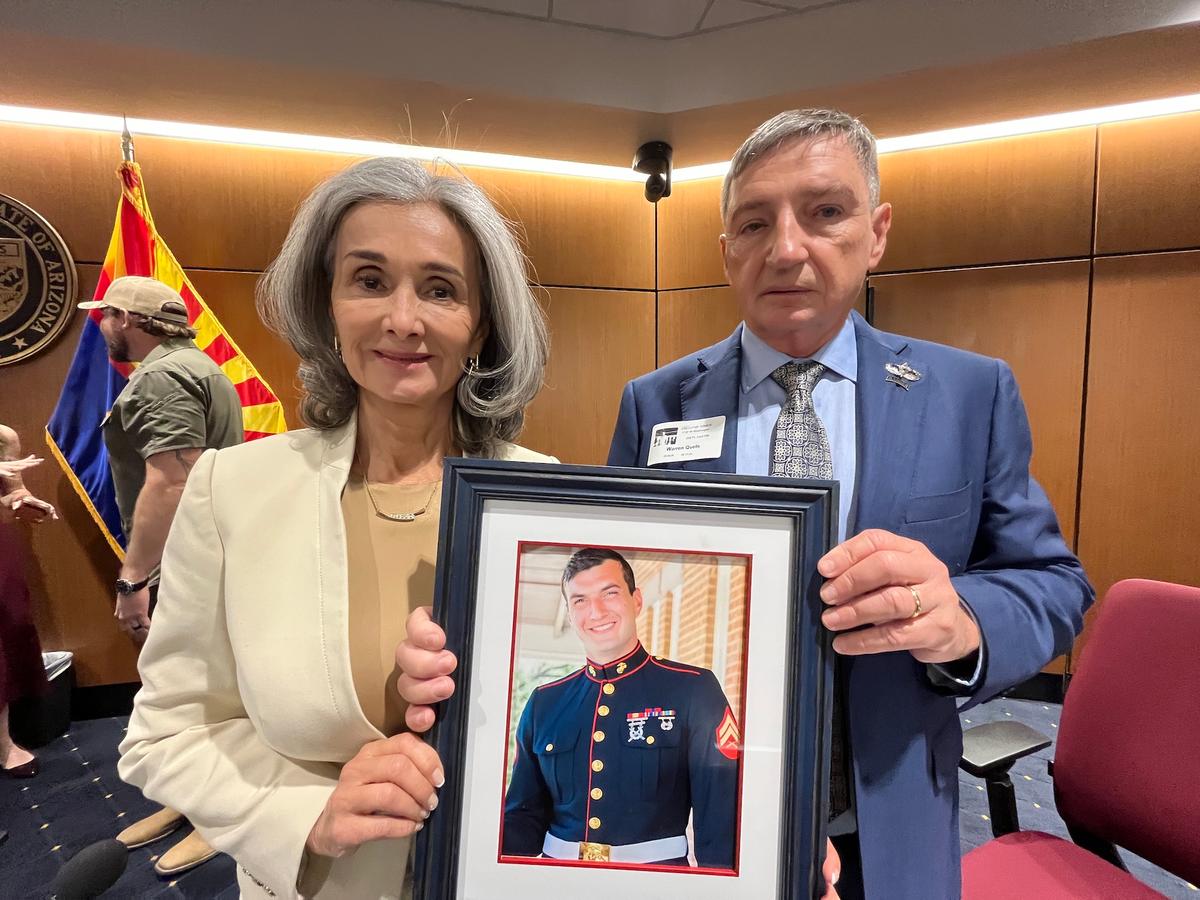 Angel Family parents Patricia and Doug Quets hold a framed picture of their son, Nicholas, who was killed by cartel members during a carjacking in Mexico in 2024. (Allan Stein/The Epoch Times)
