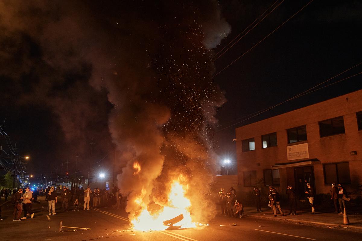People watch a burning barricade near the Delaney Hall detention center during a protest against the transfer of detainees and federal immigration policies in Newark, N.J., on May 30, 2026. (AP Photo/Andres Kudacki)