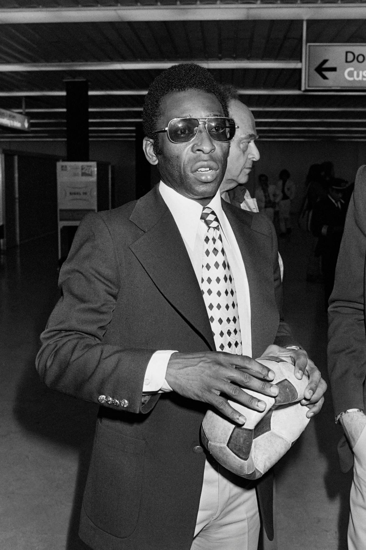 Brazilian football player Pelé arrives at Orly airport with his New York Cosmos team on Sept. 12, 1976, to attend a friendly match against Paris Saint-Germain on Sept. 15, 1976. (AFP via Getty Images)