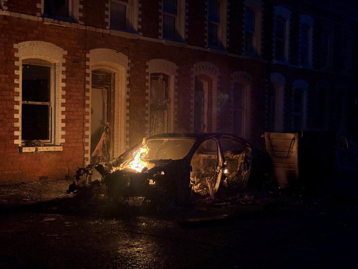 A car burns in east Belfast during a protest after a knife attack on June 8 left a man seriously injured, in Belfast, Northern Ireland, on June 9, 2026.  (Isabel Infantes/Reuters)