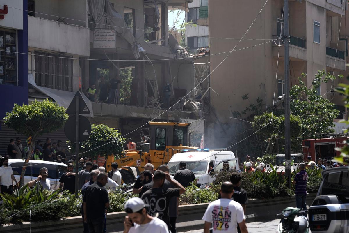 People gather at the site of an Israeli airstrike that struck an apartment in Dahiyeh, Beirut's southern suburbs, Lebanon, on June 14, 2026. (Bilal Hussein /AP Photo)
