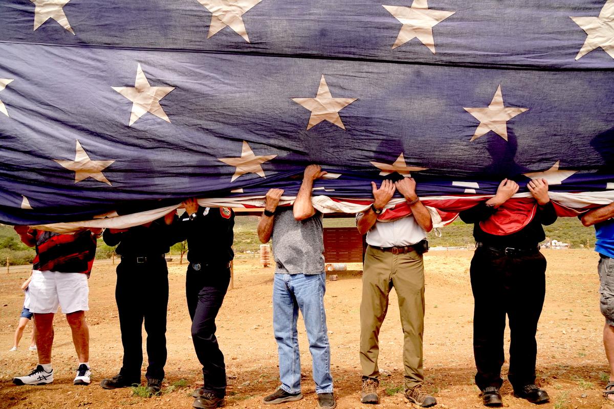 Volunteers prepare to hoist a 30-by-60-foot American flag during a Flag Day Ceremony at Foothills Ranch in Mayer, Ariz., on June 14, 2026. (Allan Stein/The Epoch Times)