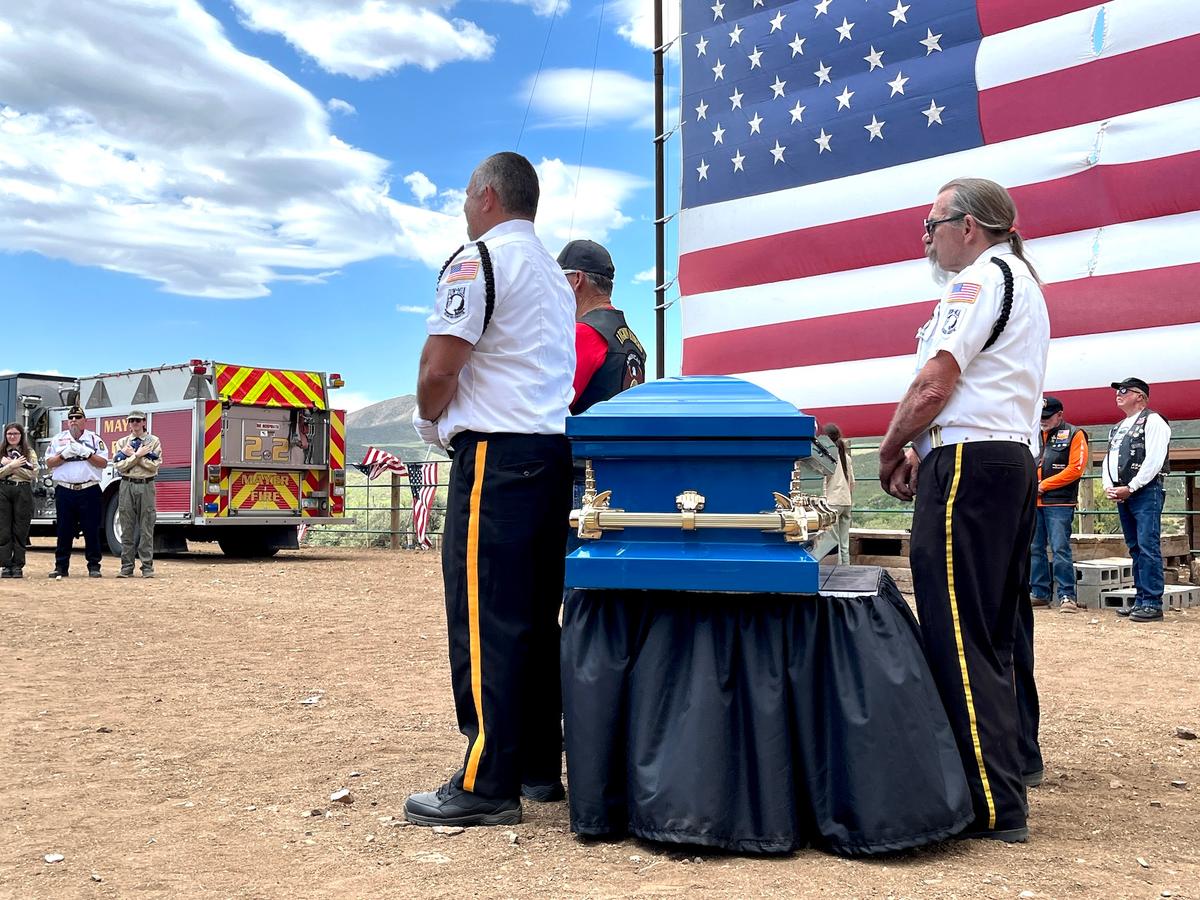 Volunteers prepare to seal 13 retired American flags in a blue wooden coffin during a Flag Day ceremony in Mayer, Ariz., on June 14, 2026. (Allan Stein/The Epoch Times)