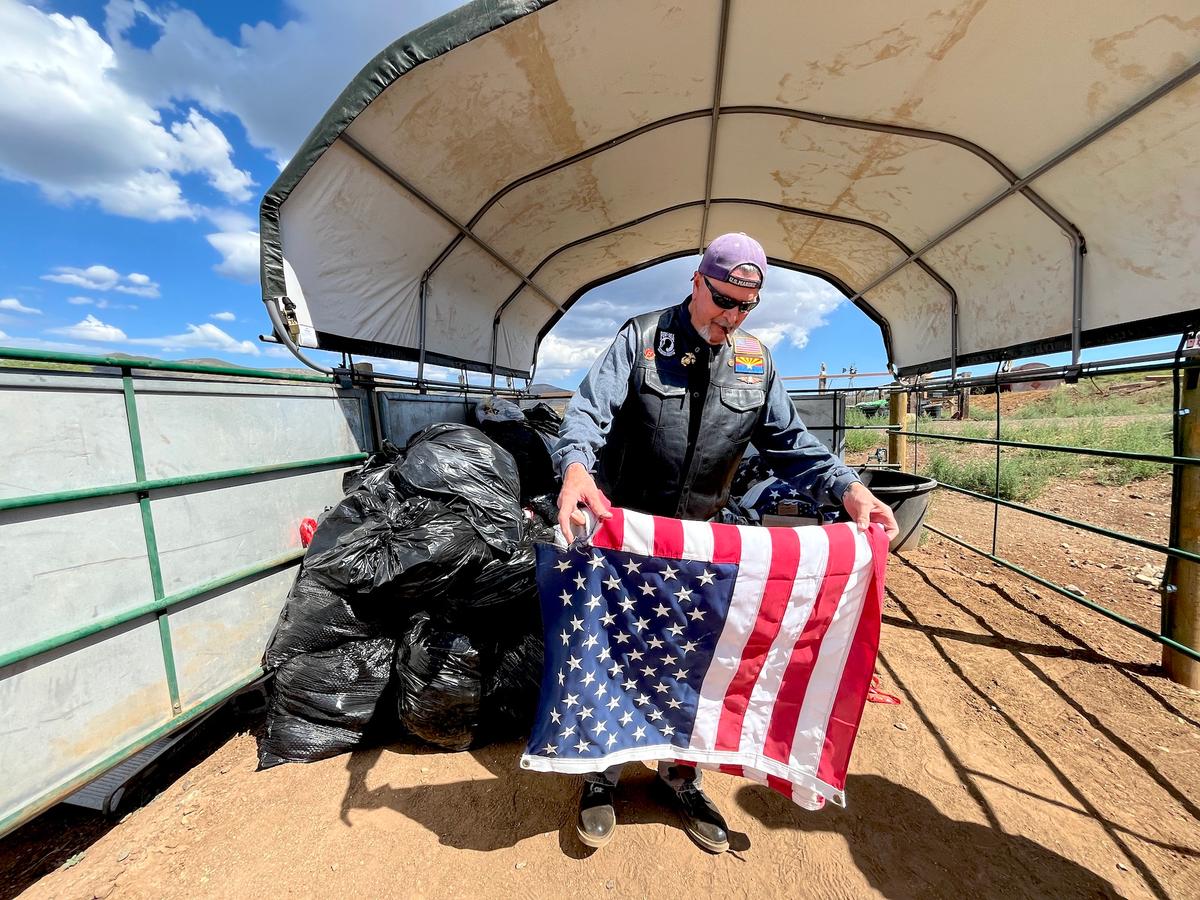 A volunteer folds an old American flag during a flag retirement ceremony on Flag Day in Mayer, Ariz., on June 14, 2026. (Allan Stein/The Epoch Times)