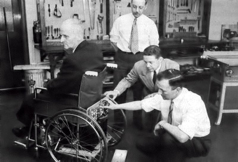 George Klein (R) demonstrates his electric wheelchair at the National Research Council of Canada in 1953. (Public Domain)