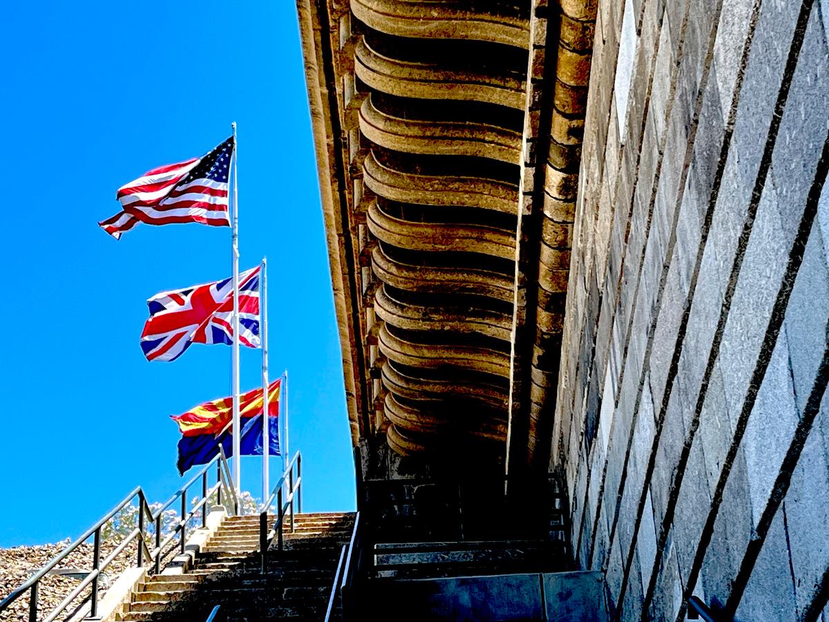 The flags of the United States, the UK, and Arizona stand above the London Bridge in Lake Havasu City, Ariz., on June 5, 2026. (Allan Stein/The Epoch Times)