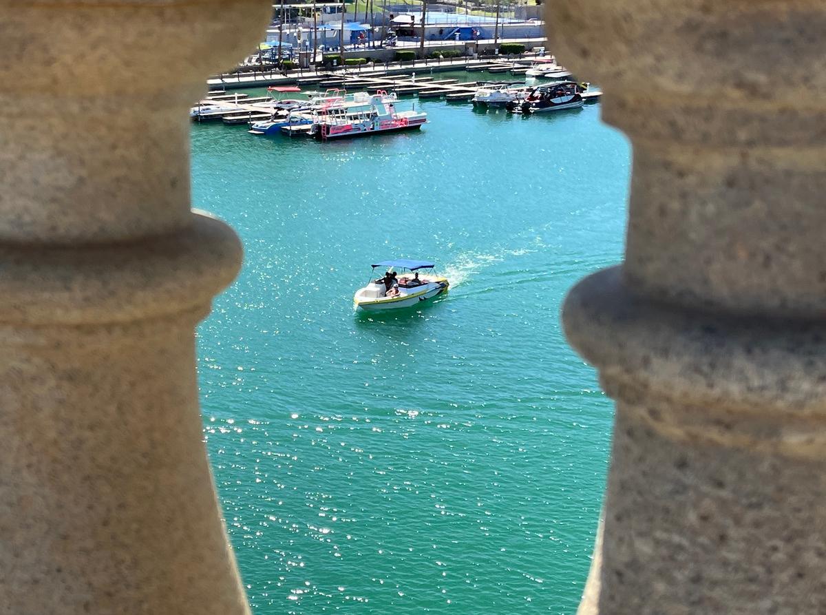 A motorboat slowly makes its way across Lake Havasu as seen through the London Bridge on June 5, 2026. (Allan Stein/The Epoch Times)