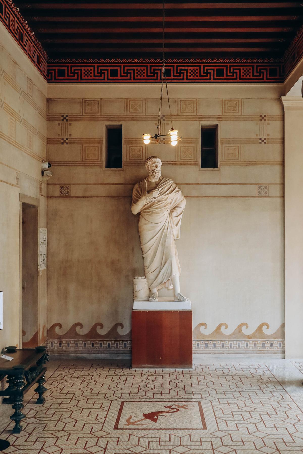 The entrance vestibule, like other areas of the home, is decorated from floor to ceiling. Its frescoes symbolize peace and war. At the far end of the vestibule, an imposing statue of Solon, a wise Athenian statesman, surveys the scene. (Andrei Antipov/Shutterstock)