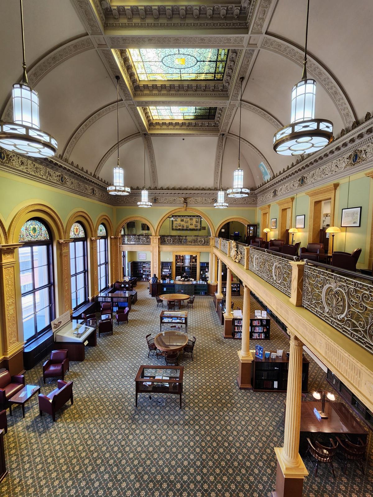 The refined State Library interior features wood shelving and paneled walls, along with climate-controlled archival storage designed to preserve legislative documents. Granite structural elements echo the building’s enduring New England stone construction. Founded in 1826, the library has evolved from a legislative resource into a robust research center, serving lawmakers, historians, and scholars. (ChicagoPhotographer/Shutterstock)