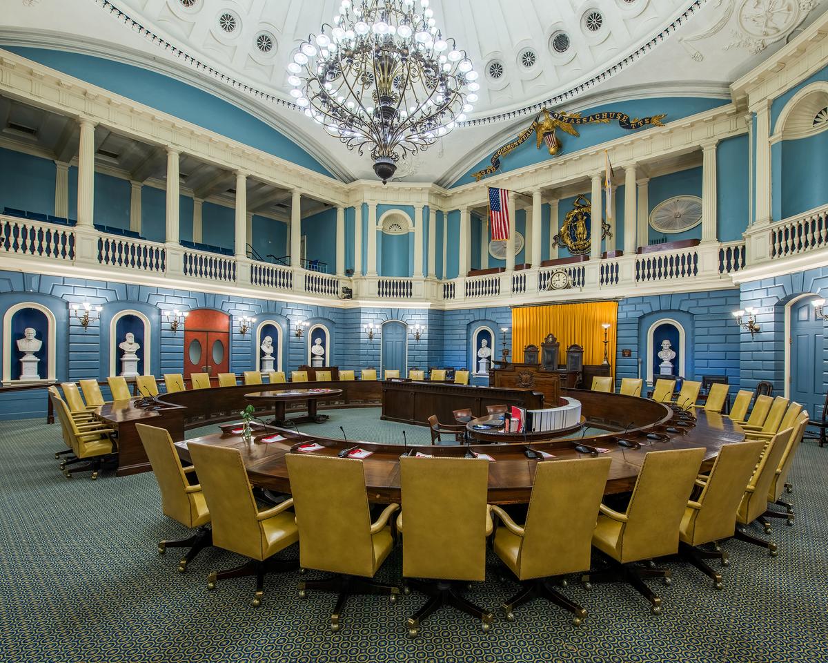 The Massachusetts Senate Chamber includes balcony-level public viewing galleries overlooking the floor below. Along the chamber’s walls are marble niches honoring prominent historical figures such as George Washington, Abraham Lincoln, Benjamin Franklin, Marquis de Lafayette, and Charles Sumner. In 2024, a bronze bust of Frederick Douglass was installed, marking the first time a person of color has been honored in this way within the State House. (Nagel Photography/Shutterstock)
