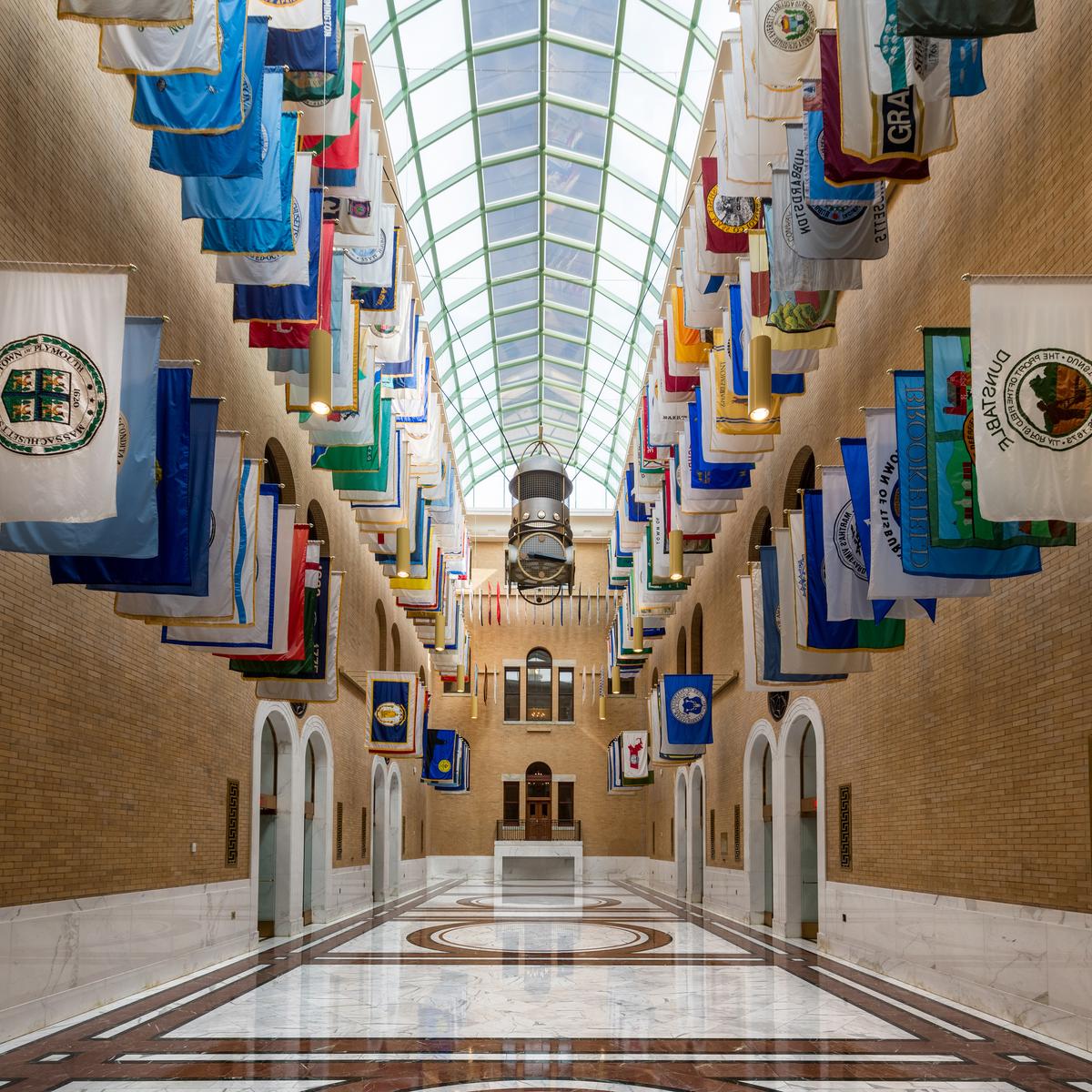 The impressive Great Hall of Flags in the Massachusetts State House was completed in 1990, rising from the basement and capped with a glass dome. This elegant tri-colored marble hall features a brilliant glass ceiling, while its walls are lined with flags representing municipalities across Massachusetts. (Nagel Photography/Shutterstock)