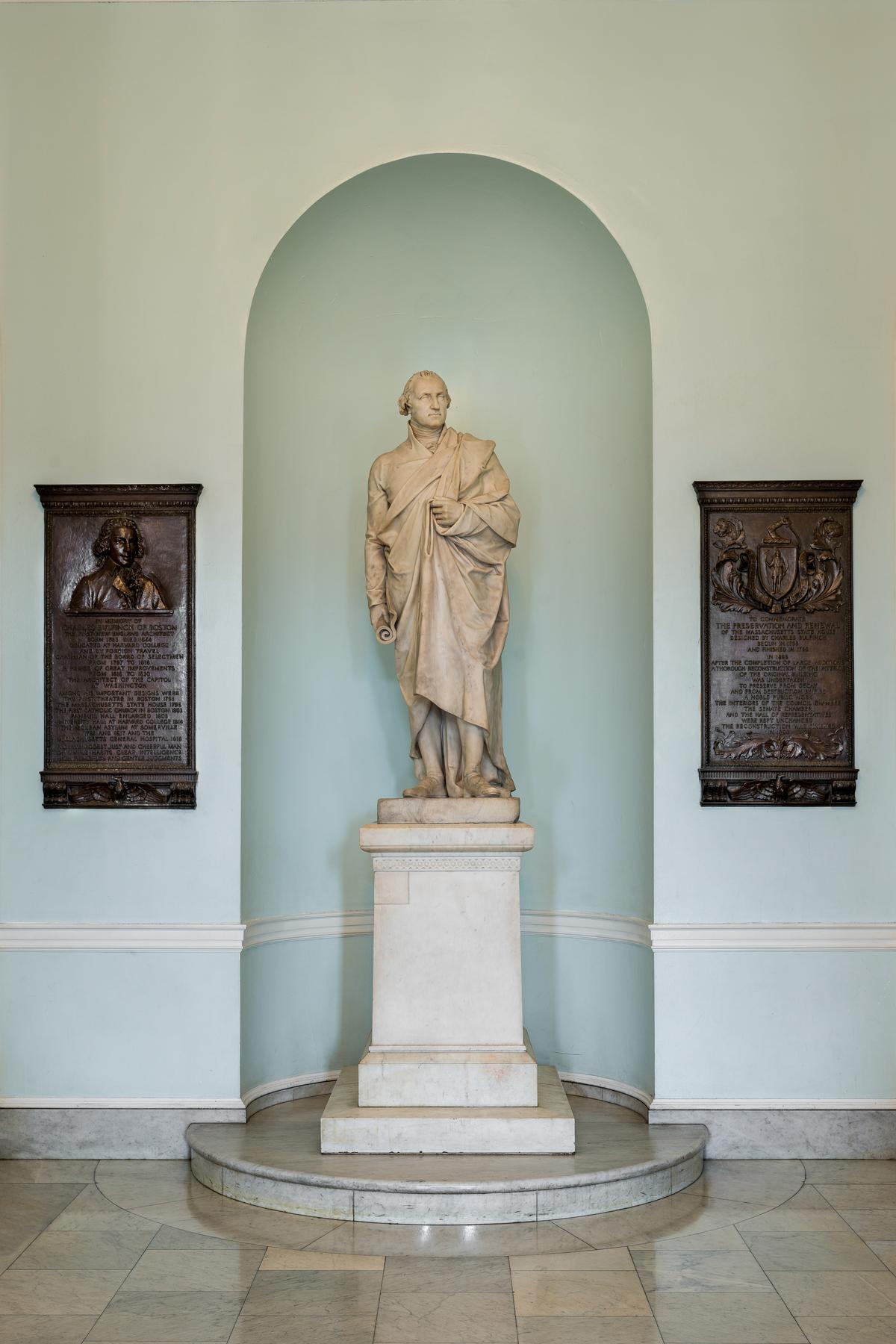 This life-size statue of George Washington, the first monumental marble sculpture in Boston, was created by Sir Francis Chantrey in 1826 and dedicated in 1827. It shows Washington in a Roman senator’s toga draped over his Revolutionary War uniform, reflecting a broader early 19th-century debate between historical accuracy and classical idealization. The work is displayed in Doric Hall. (Nagel Photography/Shutterstock)