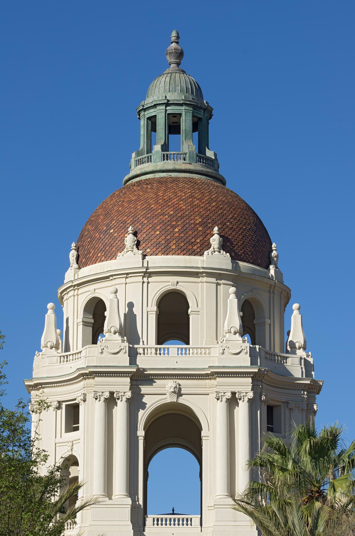 Six stories high and tiered with columns, Pasadena City Hall’s flagship circular tower includes a 26-foot high dome with a 54-feet diameter and a 41-foot-tall cupola. Red fish-scale tiles cover the dome. Columns, arches, a lion’s head mascaron, pilasters, swags, dentil molding, balustrades, an entablature, and lantern obelisks with ball finials are the tower’s primary embellishments. (Angel DiBilio/Shutterstock)