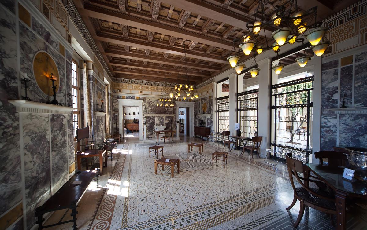 The walls of the impressive “andron,” or men’s reception room, are clad in Italian marble. At the salon's far end is a household altar made of Carrara marble that served as a place for offerings. The room’s mosaic illustrates the famous legend of Theseus slaying the Minotaur. A large, silver-plated krater (far right, front) on a table is a reproduction of a first-century-B.C. vase. (Isogood_patrick/Shutterstock)