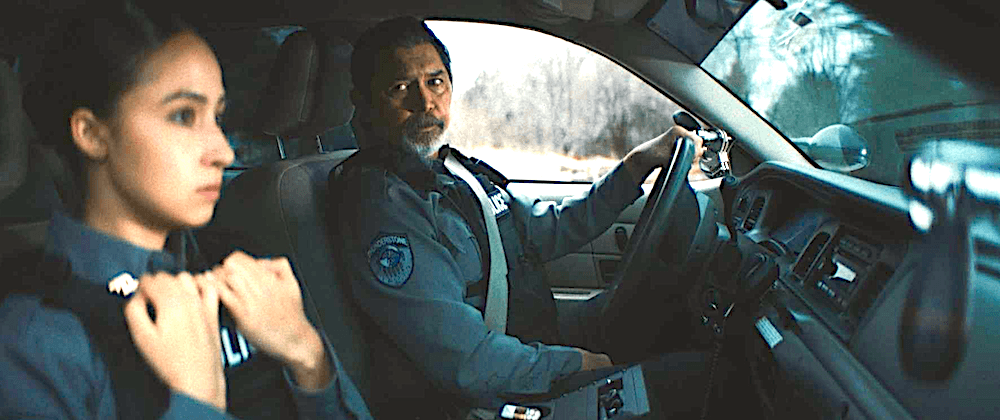 Tribal police officers Sandra Scala (Dana Namerode), and Teddy Sharpe (Lou Diamond Phillips) in their squad car in "Gangland" (Randomix Productions/Saban Films)