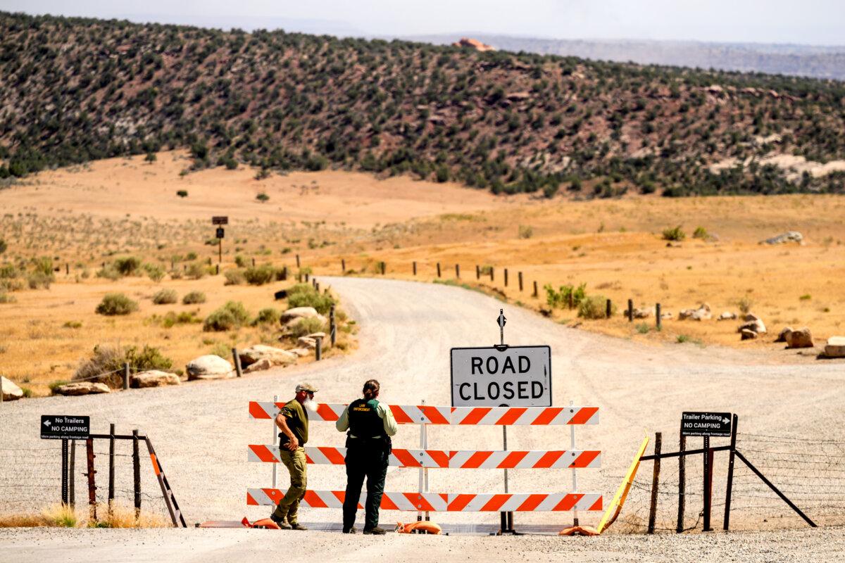 Law enforcement officers staff a roadblock as the Snyder Fire burns near Mack, Colo., on June 28, 2026. (AP Photo/Noah Berger)
