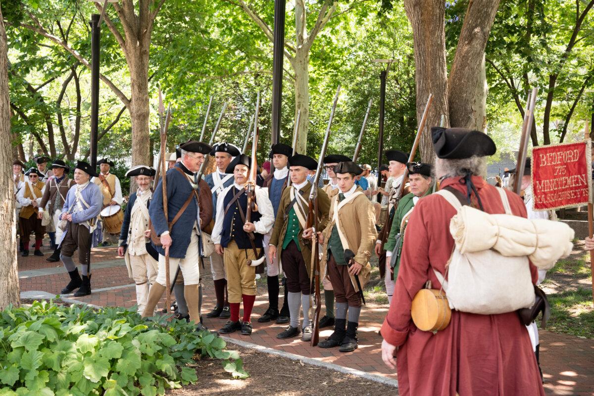 Thousands of costumed performers  take a break in the shade around Philadelphia Independence Mall, as they celebrate America's 250th anniversary, on July 3, 2026. (Larry Dye/The Epoch Times)