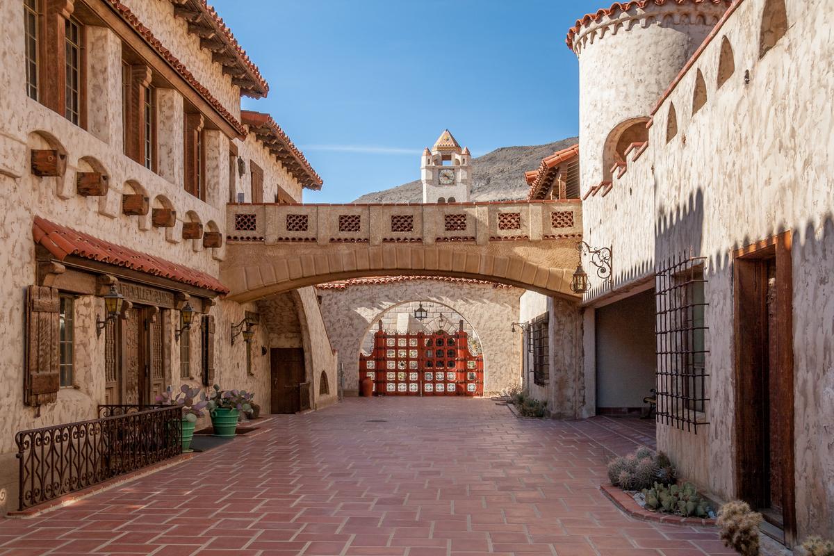 A tiled courtyard is between Scotty’s Castle’s main 10-room house and the 13-room annex, which includes guest quarters and storage space. Connecting practically and visually the upper floor of the two structures is a wide walkable arched bridge. The wood-frame exterior’s concrete and stucco exterior is evident in the courtyard, as are the many upper and lower outdoor living spaces. Hand-wrought iron is an adornment inside and outside of Scotty’s Castle, as are vigas, which are protruding wooden beams. (Laurens Hoddenbagh/Shutterstock)