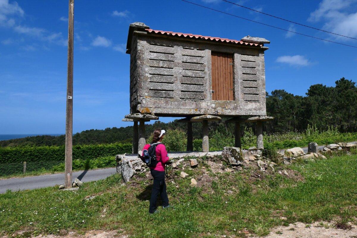 A hiker in Spain passes by a horreo used to store grain during the winter months. (Photo courtesy of Doug Hansen)