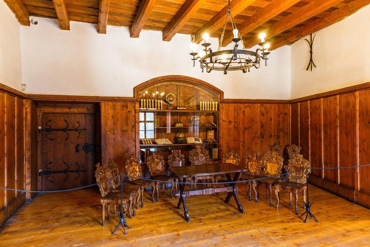 Set within the Corvinus Palace, the Knight's Hall marks Orava Castle's shift from military stronghold to aristocratic residence. Red spruce wood lines the interior, shaped during 19th-century Neo-Gothic renovations, while late Gothic and Renaissance details recall its use for feasts and receptions. Solid oak furniture, sturdy and sparingly carved, completes the Central European Renaissance atmosphere. (Tartezy/Shutterstock)