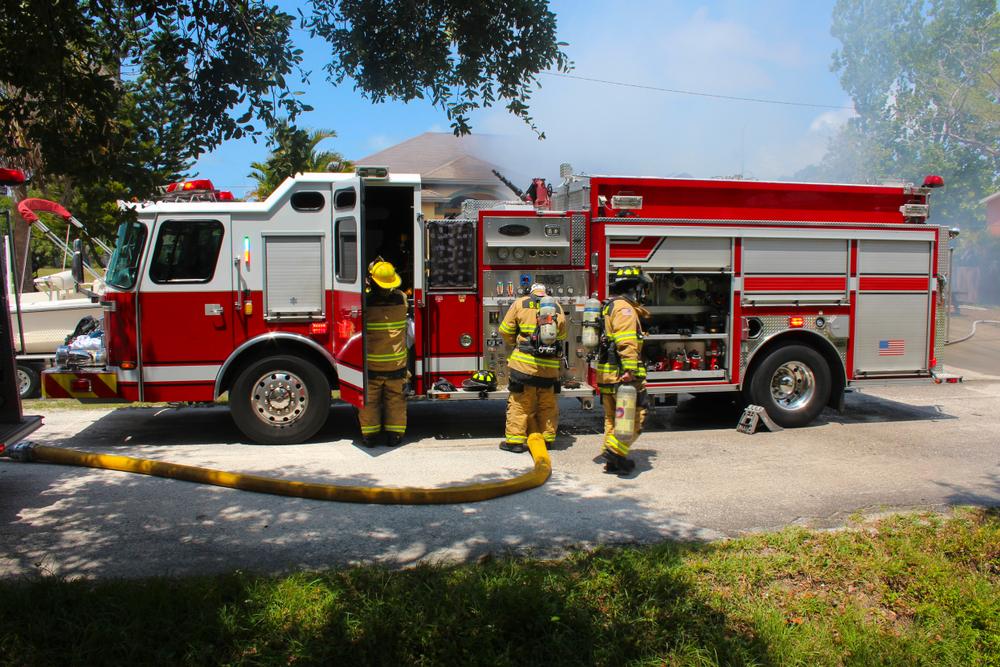 Firefighters at fire truck getting ready to fight fire. (Robert Wilder, Jr./Shutterstock)