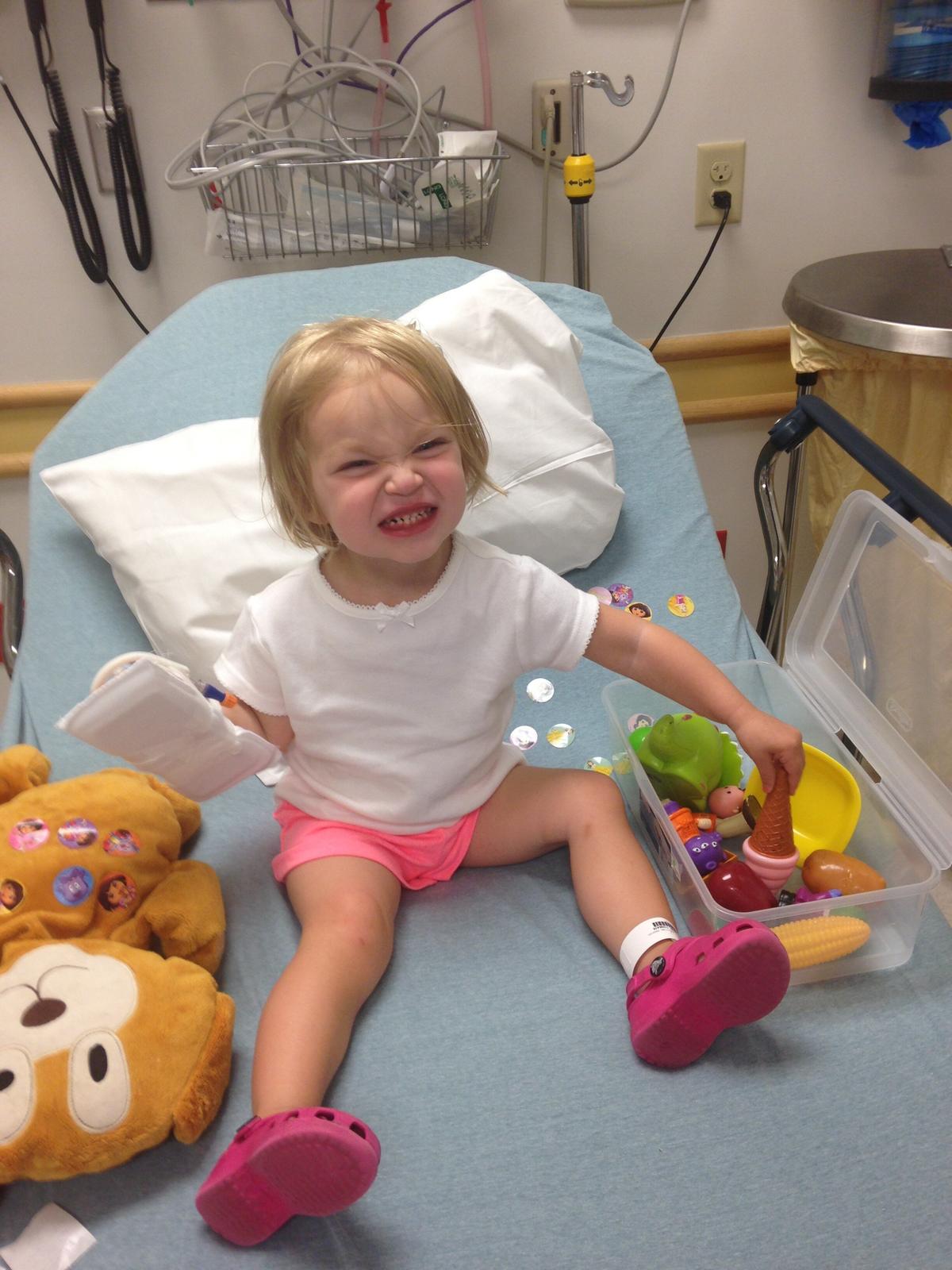 Payton Obert, when she was 2 years old, plays with Teddy, a bear gifted to her while she was a patient at Cincinnati Children's Hospital Medical Center in 2014—which later inspired her to start a charity. (Courtesy of Jess Obert)
