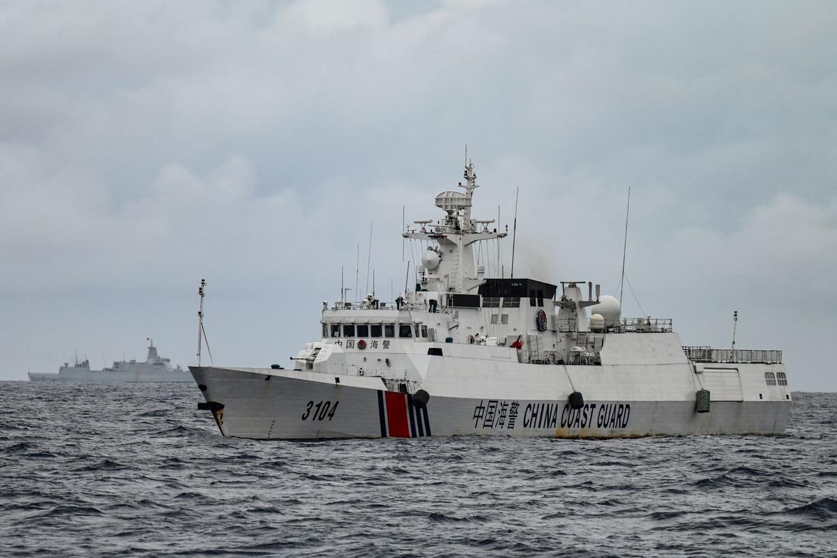 A Chinese coast guard ship (right) and a vessel identified by the Philippine coast guard as a Chinese navy ship (background left) are seen from the Philippine coast guard vessel BRP Cabra during a supply mission to Sabina Shoal in disputed waters of the South China Sea on Aug. 26, 2024. (Jam Sta Rosa/AFP via Getty Images)