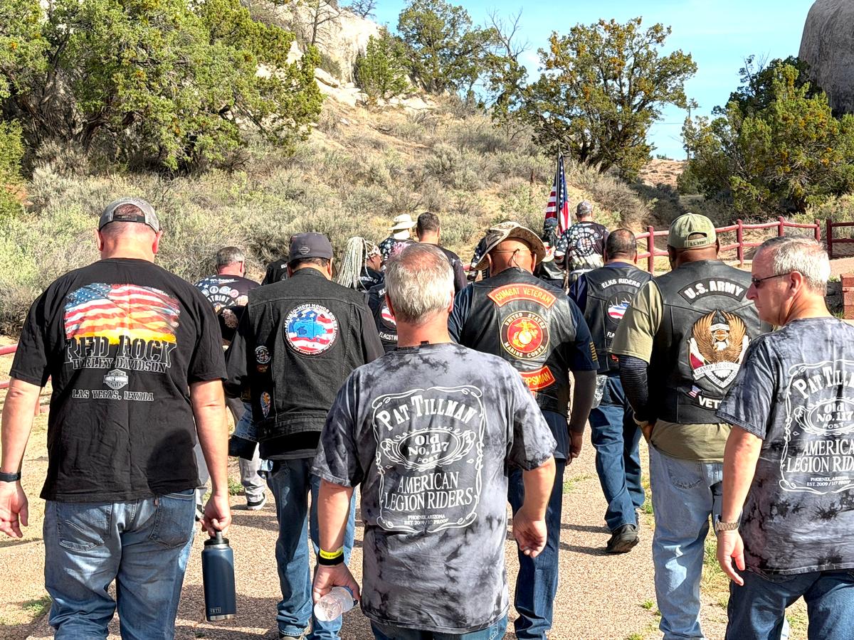 Motorcycle riders walk to the gathering point for a flag-passing ceremony in Window Rock, Ariz., on July 28, 2026. (Allan Stein/The Epoch Times)