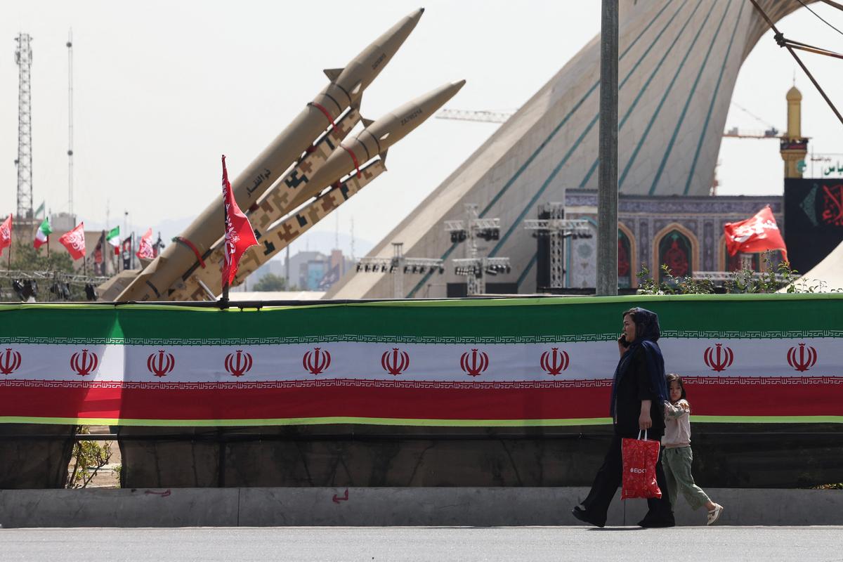 A woman and a child walk past Iranian-made Zolfaghar missiles displayed at Azadi Square in Tehran, Iran, on July 24, 2026. (AFP via Getty Images)