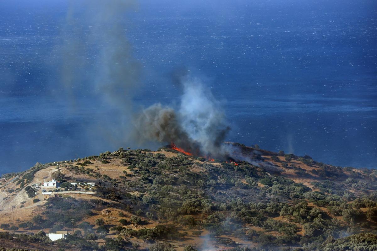 Flames and smoke rise as a wildfire burns near the beach of Triopetra on the island of Crete, Greece, July 30, 2026. (Stefanos Rapanis/Reuters)