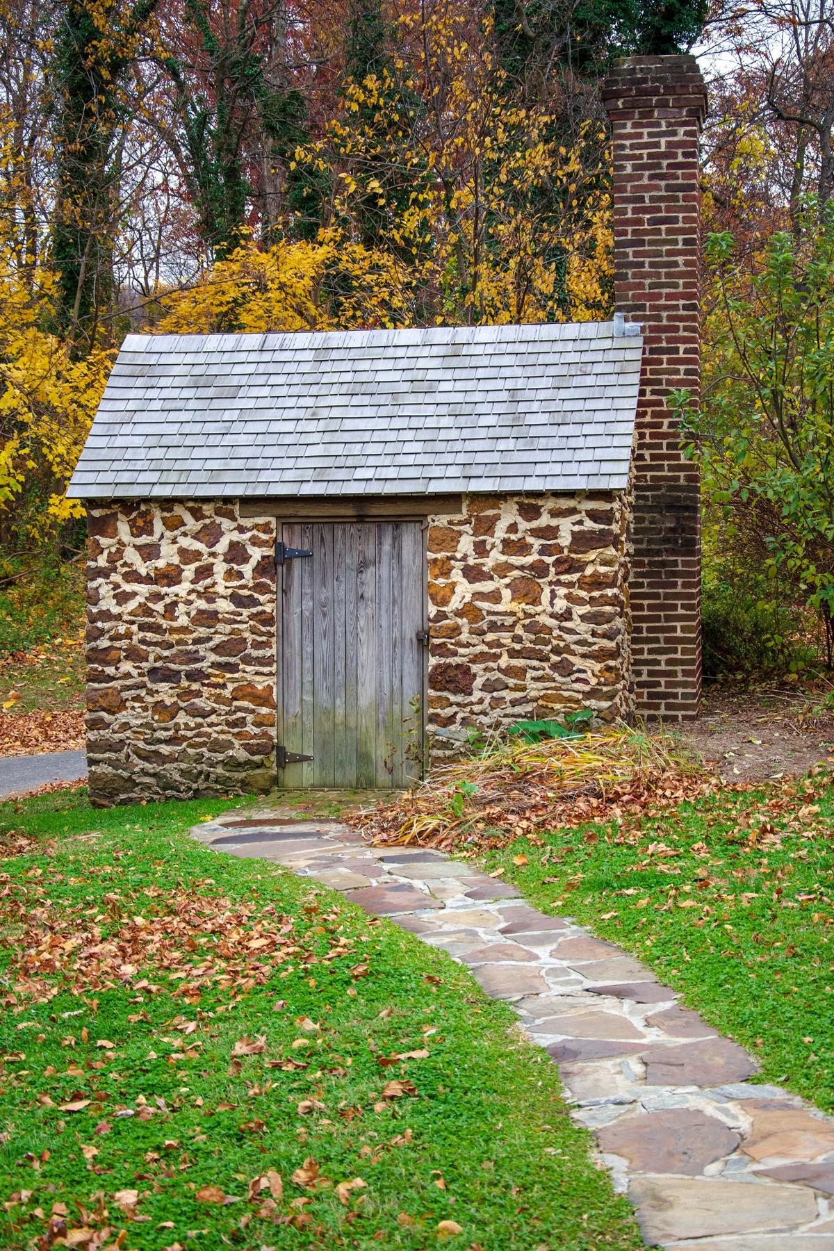 Outside the main house, and at the end of a fieldstone walkway, is a small stone cabin with a brick chimney and cedar-shingle roof that Douglass referred to as the Growlery. The term was introduced in British author Charles Dickens’s novel “Bleak House” to describe a private space for venting frustrations and contemplating life. Inside, Douglass equipped the simple space with a desk and chair. (Zack Frank/Shutterstock)