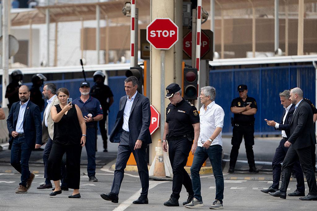 Spanish Prime Minister Pedro Sanchez (C) and Minister of the Interior Fernando Grande Marlaska walk by the Tarajal border fence between Spain's North Africa's Ceuta exclave and Morocco during a visit to manage one of the largest illegal immigrant crises on the country's border as thousands of migrants crossed overnight from Morocco on July 31, 2026. (Jorge Guerrero/AFP via Getty Images)