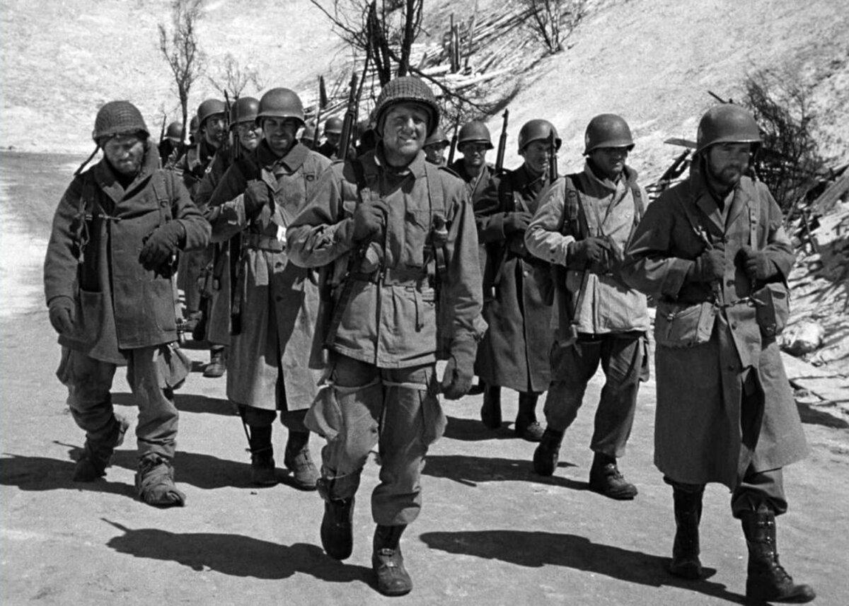 Sgt. Kinnie (James Whitmore, L), Pvt. Holley (Van Johnson, C), and other soldiers, in “Battleground.” (MGM)