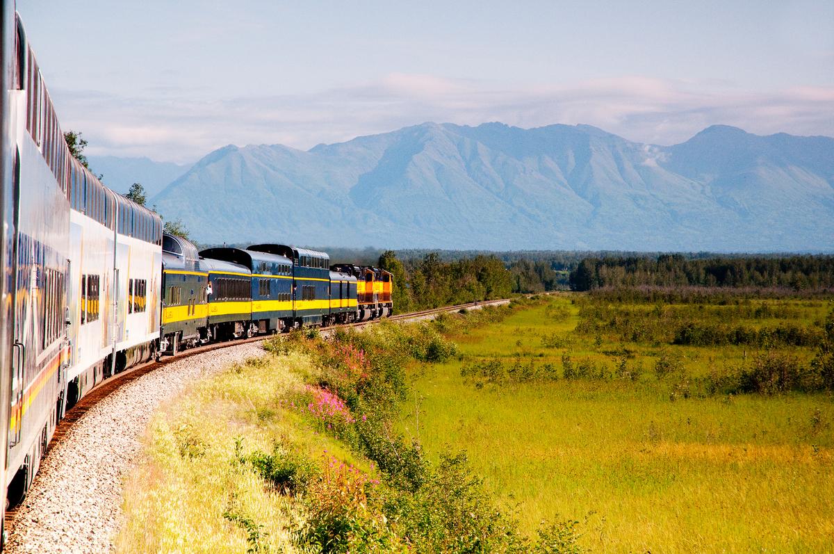 The Alaska Railroad glides past snow-capped peaks on its journey toward Denali National Park and Fairbanks. (Gail Shotlander/Getty Images)