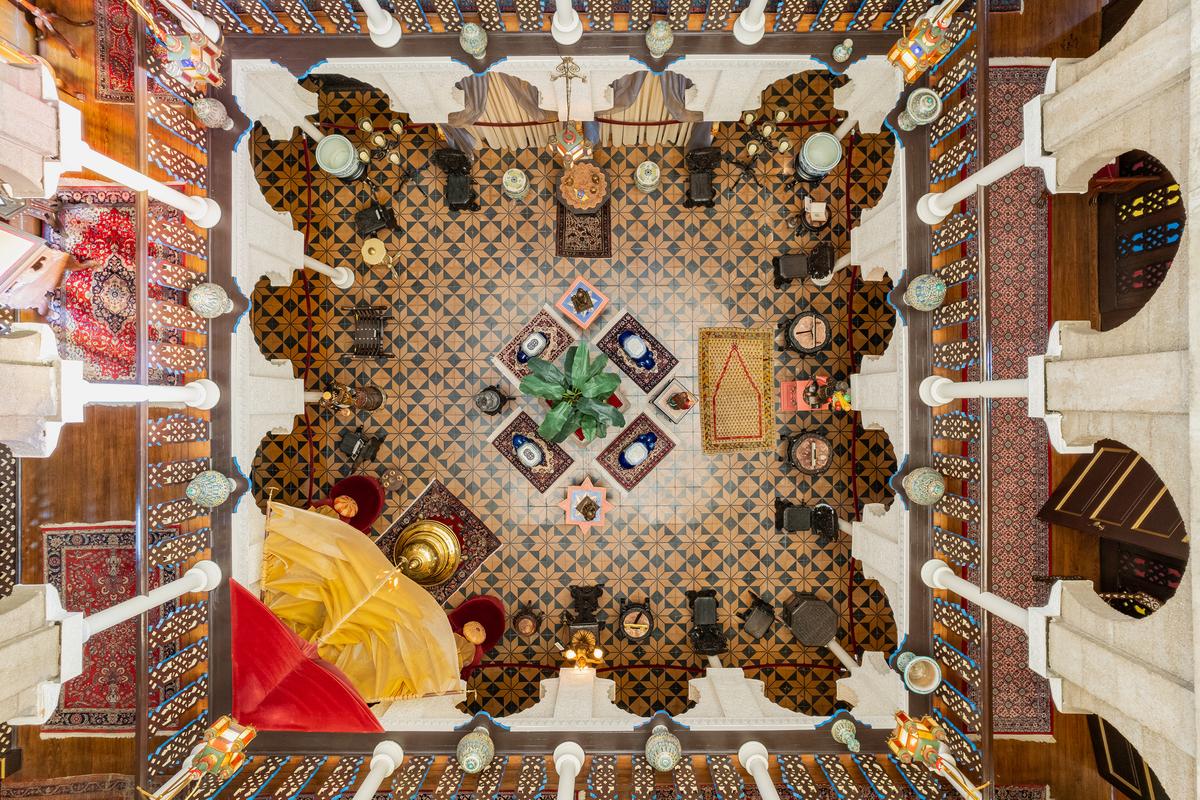The central hall’s floor is crafted of 350-year-old tiles from Seville, Spain. Tiles on the walls are from Egypt. The view from above resembles a detailed painting, featuring jewel-toned shapes and patterns, as well as symmetry from the columns and arches. (Villa Zorayda Museum)