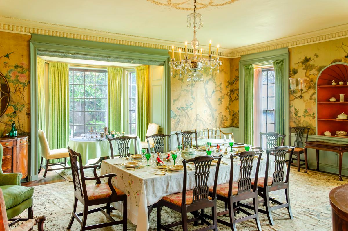 The green dining nook mirrors the garden beyond it. A bay window frames sweeping views of the Pan Garden, blurring the line between inside and out, while doors on either side offer direct access to the grounds. At the touch of a button, the center pane lowers into the basement, and a screen rises in its place, turning the nook into an airy, screened-in retreat. (Longue Vue House and Gardens)