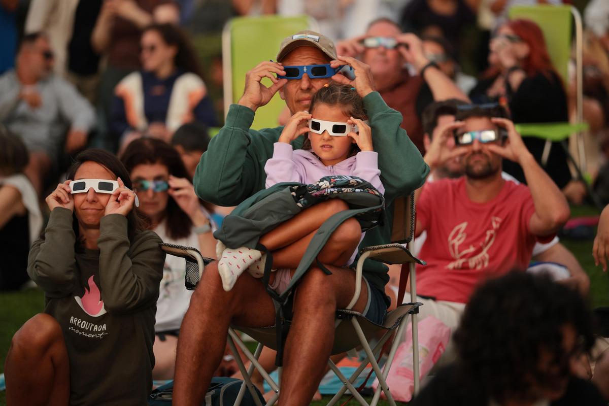 People using solar eclipse sunglasses as they observe the total solar eclipse at El Monte De San Pedro park in A Coruña, Spain, on Aug. 12, 2026. It was the first time a total solar eclipse, when the sun is blocked by the moon's orbit, could be viewed from Spain since 1905. (Chip Somodevilla/Getty Images)