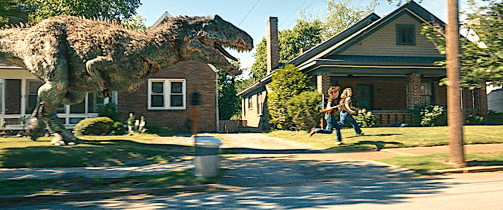 Brian (Christian Convery) and Audrey (Maisy Stella) run from a T-Rex, in "The End of Oak Street." (Warner Bros. Pictures)