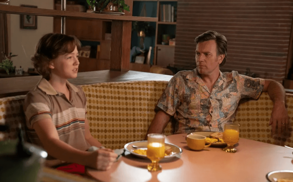 Father (Ewan McGregor) and son (Christian Convery) at the dinner table, in "The End of Oak Street." (Warner Bros. Pictures)