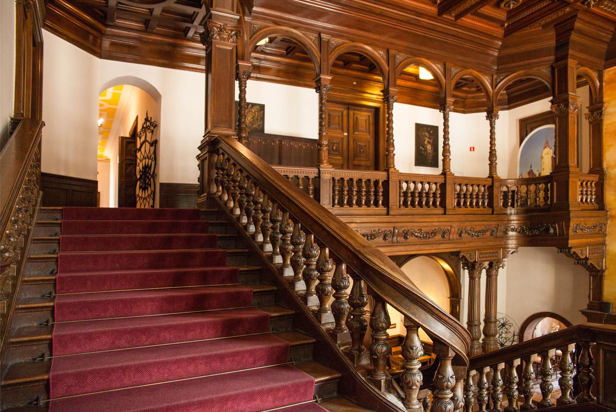 This staircase demonstrates Moszna Castle’s Renaissance influences. Classical square columns with Corinthian capitals, a sweeping banister over a baluster adorned with acanthus leaf carvings, and arches supported by narrow turned columns accentuate the stairwell’s coffered ceiling. (Szymon Kaczmarczyk/Shutterstock)