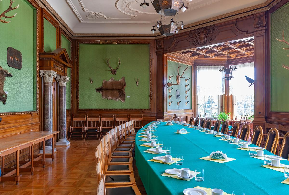 Originally referred to as Hunting Hall, because of the numerous mounted animal trophies, it was actually a dining hall. Its Renaissance features are on display in its round marble columns with Corinthian capitals, which support a classical pediment over the doorway. Carved wood pilasters and a decorative wood entablature indicate an opening to another room, where a wood coffered ceiling is visible. Wood molding frames sections of forest-green walls where the mounts are exhibited. The white, tray ceiling with elegant moldings contrasts with the room’s mostly masculine décor. (posztos/Shutterstock)