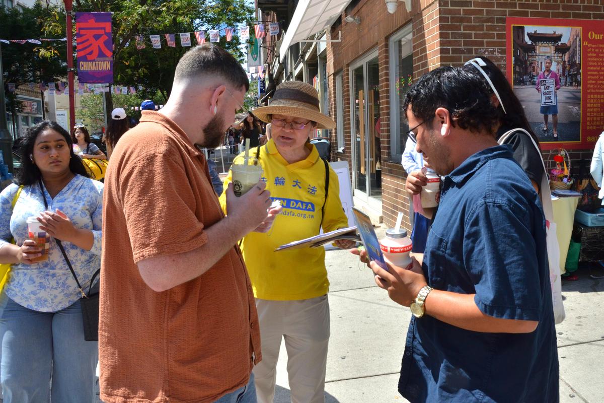 Local residents and visitors stop to learn about forced organ harvesting in China and sign petitions directed to U.S. senators. (Frank Liang/The Epoch Times)