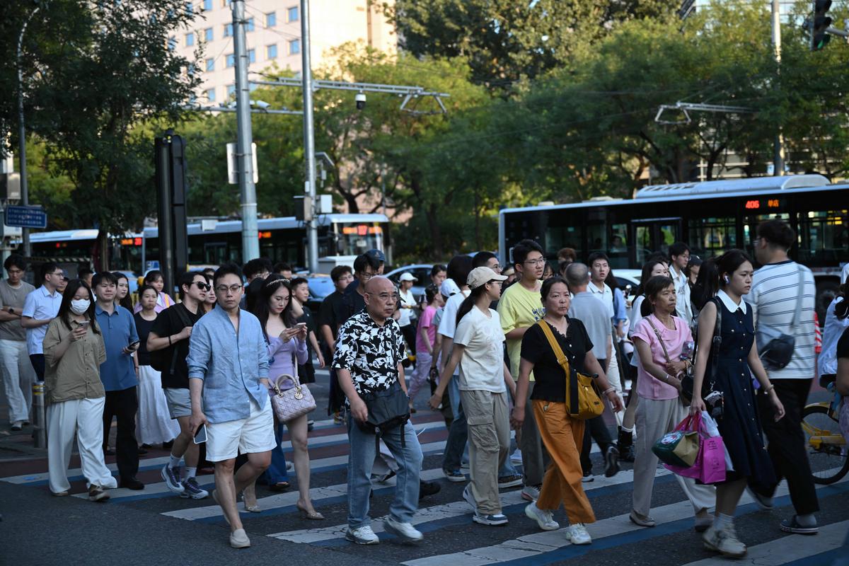 People cross a road in Beijing on Aug. 16, 2026. (Pedro Pardo/AFP via Getty Images)