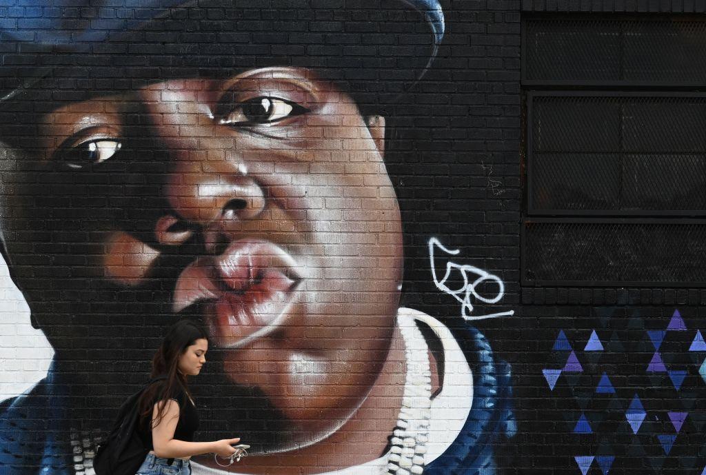 A woman passes by a mural of rapper Notorious B.I.G. (Biggie Smalls) on a wall in the Bishwick section of Brooklyn, New York City, on June 6, 2019. (Timothy A. Clary/AFP via Getty Images)
