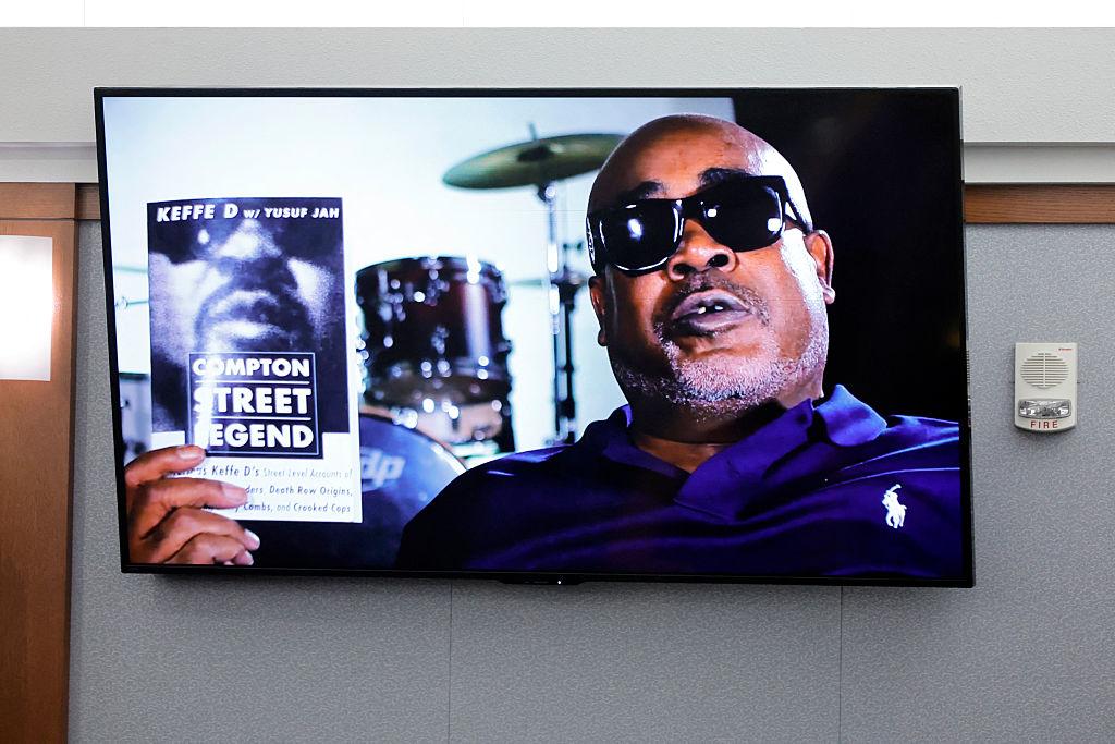 A photo of Duane Davis holding his book "Compton Street Legend" is displayed during opening statements of his murder trial, related to the 1996 killing of rapper Tupac Shakur, at Clark County District Court in the Regional Justice Center in Las Vegas, Nevada, on August 17, 2026. (Steve Marcus/AFP via Getty Images)