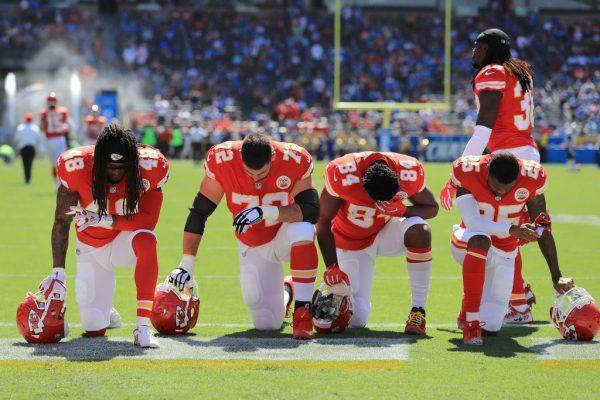 Terrance Smith #48, Eric Fisher #72, Demetrius Harris #84, and Cameron Erving #75 of the Kansas City Chiefs are seen taking a knee before the game against the Los Angeles Chargers at the StubHub Center in Carson, Calif., on Sept. 24, 2017. (Sean M. Haffey/Getty Images)