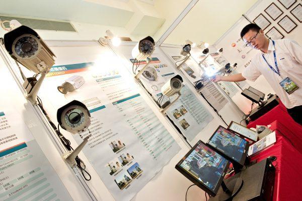 A man adjusts a surveillance camera displayed at an international exhibition on public safety and security in Shanghai on April 27, 2011. (Philippe Lopez/AFP/Getty Images)