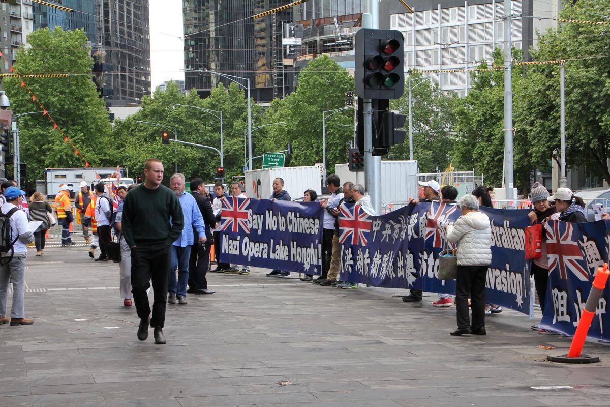 Pedestrians looking at the protest banners and boards calling on Australians to boycott “Lake Honghu” outside the Melbourne Recital Centre on Nov. 7. (Thoai Nguyen/The Epoch Times)