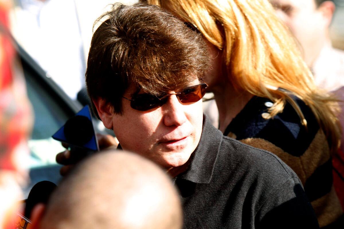 Convicted former Illinois Gov. Rod Blagojevich walks through a horde of media toward his house before giving a news conference outside his home in Chicago, on March 14, 2012. (Frank Polich/Getty Images)